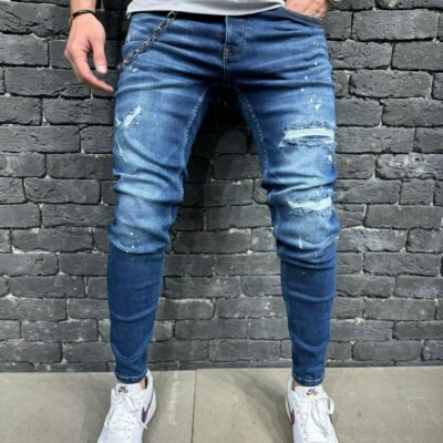 Чоловічі вузькі рвані джинси синього кольору з ланцюжком і бризками.